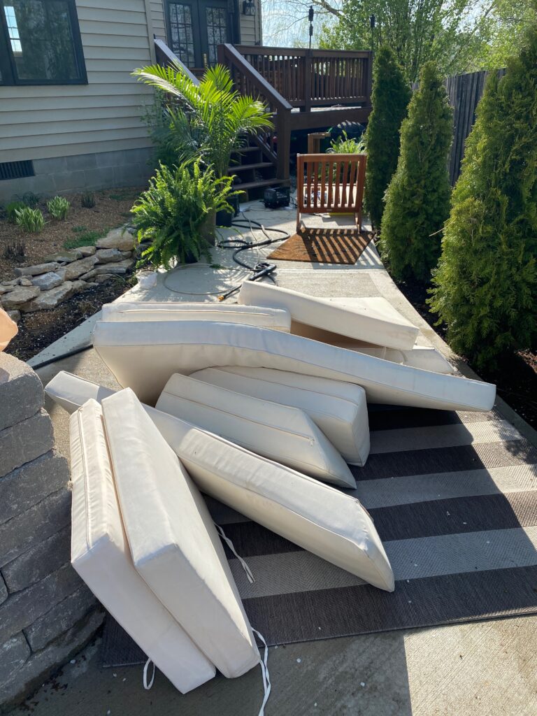 Patio cushions being power washed